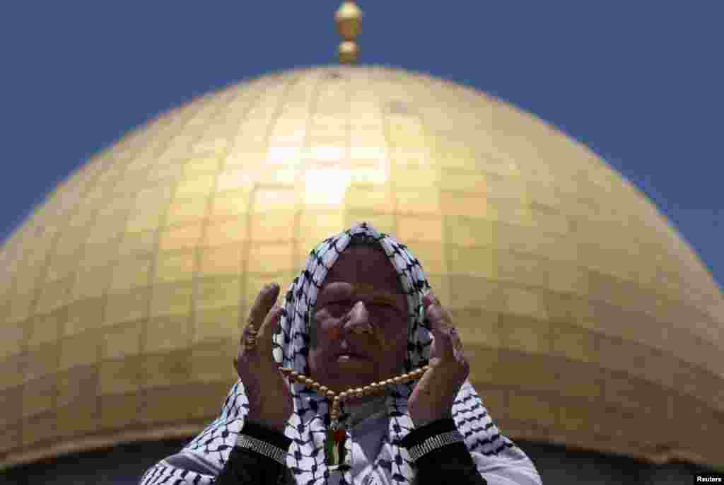 Seorang warga Palestina berdoa di depan Masjid Kubah Batu (Dome of the Rock) pada wilayah yang disebut kaum&nbsp; Muslim sebagai Al-Haram asy-Syarif (Noble Sanctuary) namun orang Yahudi menyebutnya sebagai Bait Allah (Temple Mount) di kota tua Yerusalem, dalam bulan suci Ramadan, 26 Juli 2013.