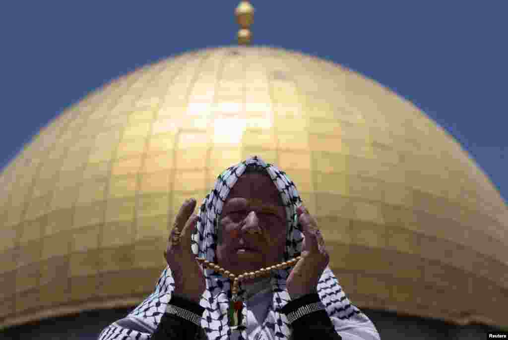 A Palestinian worshipper prays in front of the Dome of the Rock on the compound known to Muslims as Noble Sanctuary and to Jews as Temple Mount in Jerusalem's Old City, during the holy month of Ramadan, July 26, 2013.