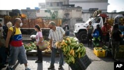 Personas usan mascarilla para evitar la propagación del nuevo coronavirus en un mercado al aire libre en Caracas. el 10 de abril de 2020.