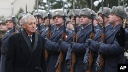US Secretary of Defense Chuck Hagel inspects a military honor guard during a welcoming ceremony in Warsaw, Poland, Jan. 30, 2014.