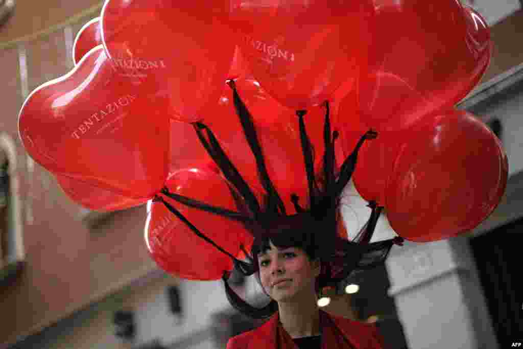 Seorang perempuan dengan rambut yang diikatkan pada balon, mengikuti acara Karnaval di Venesia, Italia.