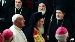 FILE - Pope Francis, left, arrives with Ecumenical Patriarch Bartholomew I to attend an ecumenical prayer at the Patriarchal Church of St. George in Istanbul, Turkey, Nov. 29, 2014. Pope Francis heads to Lesbos island on April 16, 2016, along with the spiritual leader of the world’s Orthodox Christians and the head of the Church of Greece to voice their solidarity with the refugees and migrants.