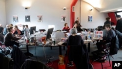 FILE - Editorial staff of the French satirical magazine Charlie Hebdo share the offices of the French newspaper Liberation, in Paris, Jan. 9, 2015. 