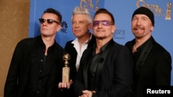 Para personil U2, Adam Clayton (kiri), Bono (kedua dari kanan), Larry Mullen, Jr. dan The Edge (kanan), berfoto setelah menerima penghargaan Best Original Song, 12 Januari 2014.