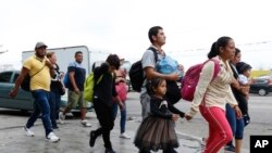 Migrantes en San Pedro Sula, Honduras, caminan por una autopista cuando una caravana de cientos de personas parte hacia Estados Unidos con la esperanza de pedir asilo. Abril 10 de 2019.