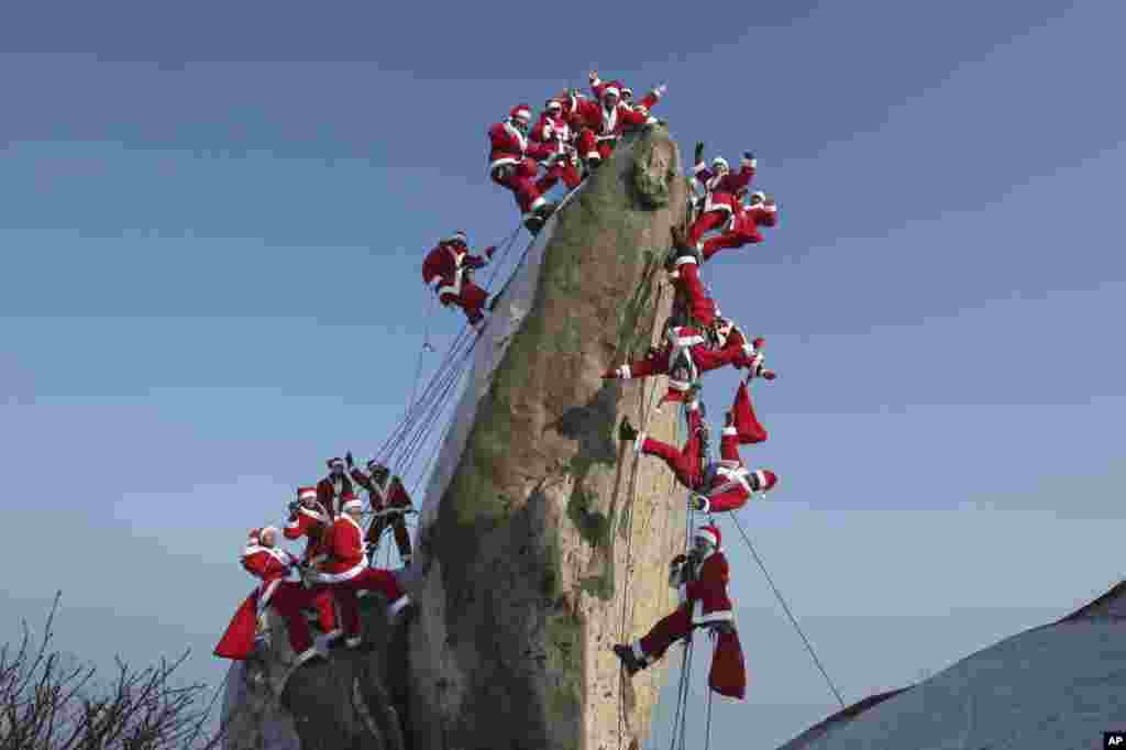 Mountain climbers in Santa Claus outfits pose during an event to hope for safe climbing and to promote Christmas charity on the Buckhan mountain in Seoul, South Korea.