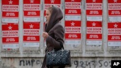A girl walks by campaign posters for socialist presidential candidate Igor Dodon, in Chisinau, Moldova, Nov. 12, 2016. 