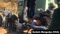 Hopewell Chin’ono' getting into a prison truck in Harare.