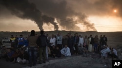 在摩苏尔以南的奎亚拉油田燃烧的同时，被伊拉克国家安全人员拘押的人在一个检查哨所接受审问（2016年11月5日）