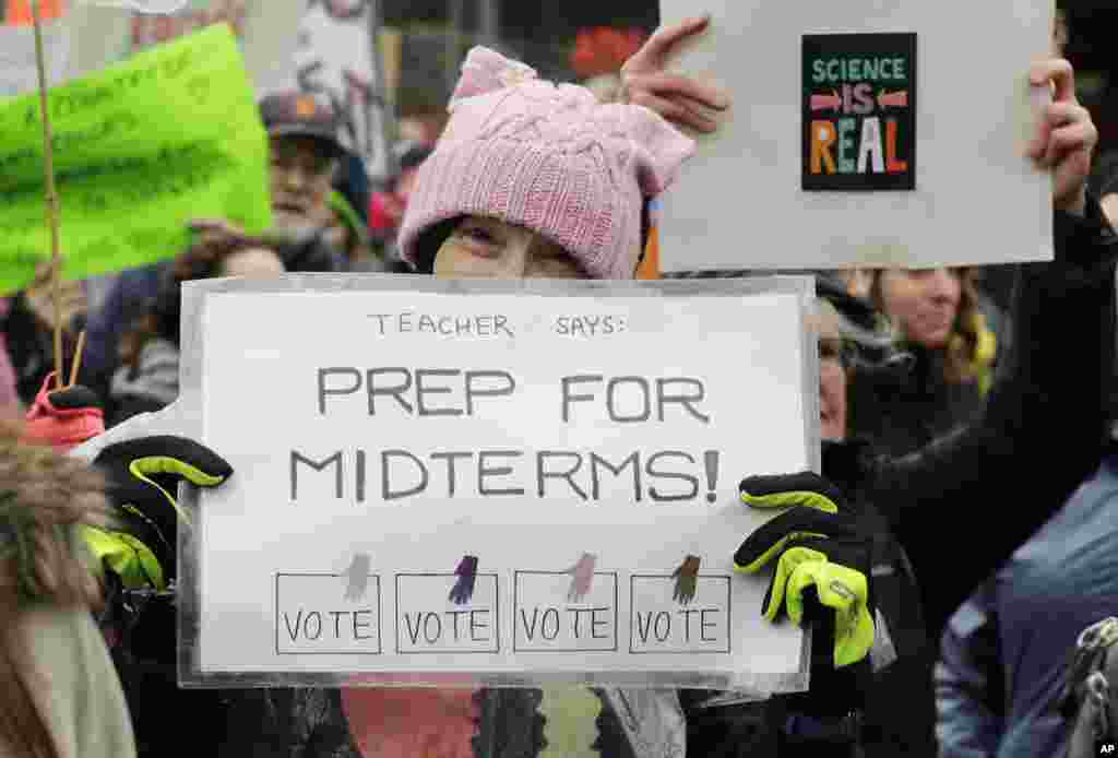 A woman holds a sign promoting voting in the upcoming midterm elections during a Women's March in Seattle, Jan. 20, 2018. The march was one of dozens planned across the U.S. over the weekend. 