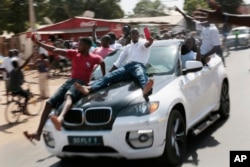 Gambians celebrate the victory of opposition coalition presidential candidate Adama Barrow in the streets of Serrekunda, Gambia, Dec. 2, 2016.