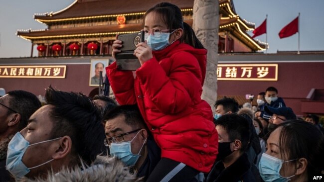 北京天安门前戴着口罩的游人。（2020年1月23日）