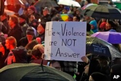 Un niño sostiene un cartel en la intersección de las avenidas Murray y forbes, en el vecindario de Squirrel Hill, en Pittsburgh, Pensilvania, el sábado por la noche, durante una vigilia en honor de las víctimas del tiroteo en la sinagoga Tree of Life. Octubre 27 de 2018. Foto: AP.