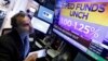 A trader watches a television screen on the floor of the New York Stock Exchange showing the rate decision of the U.S. Federal Reserve, in New York, Nov. 1, 2017.