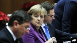 Slovenia's Prime Minister Barut Pahor (L), Germany's Chancellor Angela Merkel (C) and Finland's Prime Minister Jyrki Katainen attend a European Union summit in Brussels December 9, 2011.