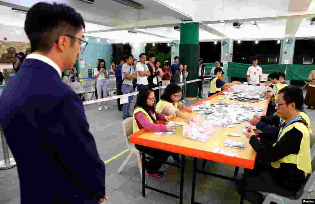 Un candidato local observa a los funcionarios que cuentan votos en una mesa electoral en Kowloon Tong, Hong Kong, China, 24 de noviembre de 2019.