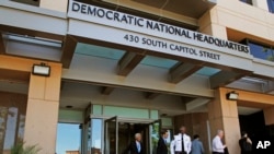 FILE - People stand outside the Democratic National Committee (DNC) headquarters in Washington, June 14, 2016.