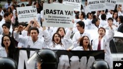 Foto de archivo donde médicos y estudiantes de medicina con pancartas que dicen: "Basta de la intromisión de los tribunales ecuatorianos contra los médicos", durante una protesta contra la ley que penaliza la negligencia médica en Quito.