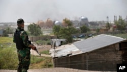 An Iraqi federal police officer stands guard outside the natural gas plant in Taji, 20 kilometers north of Baghdad, Iraq, May 15, 2016. The plant was targeted by an apparant Islamic State attack.