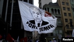 Demonstrators attend a protest against Brazil's President Michel Temer and his government reforms in Rio de Janeiro, Brazil, Nov. 10, 2017. The flag reads "Out, Temer."