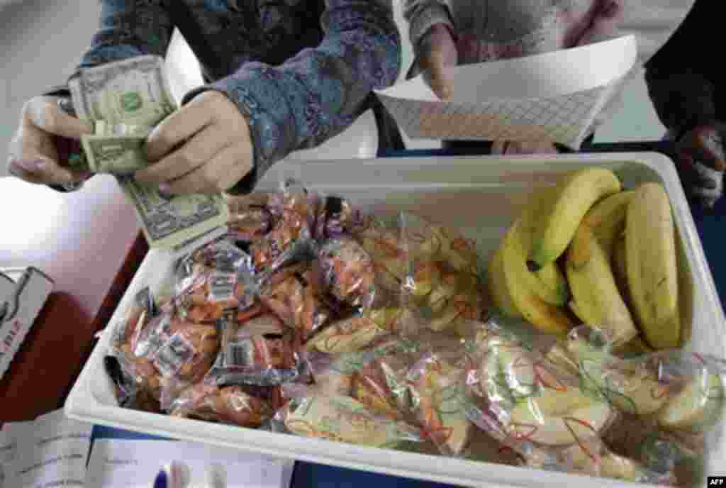 A student at Fairmeadow Elementary School pays for lunch of fruits and vegetables during a school lunch program in Palo Alto, Calif., Thursday, Dec. 2, 2010. More children would eat lunches and dinners at school under legislation passed Thursday by the Ho