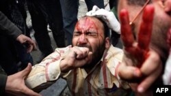 Protivnici egipatske vlade pomažu jednom od ranjenih u današnjim sukobima na kairskom trgu Tahrir