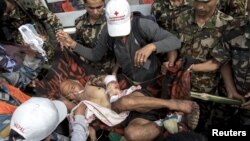 Nepal military personnel and aid workers carry earthquake victim Buddha Gurung on a stretcher after he arrives by helicopter from his village in Pokkara airport, April 30, 2015. 