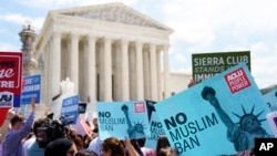 Para pengunjuk rasa mengangkat poster dan menyerukan penentangan terhadap keputusan Mahkamah Agung yang menegaskan larangan perjalanan yang dikeluarkan Presiden Donald Trump di luar gedung Mahkamah Agung di Washington, D.C., 26 Juni 2018 (foto: AP Photo/Carolyn Kaster)