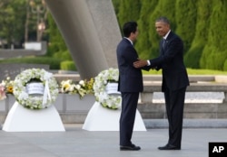 FILE - U.S. President Barack Obama, right, shakes hands with Japanese Prime Minister Shinzo Abe at Hiroshima Peace Memorial Park in Hiroshima, western Japan, May 27, 2016.
