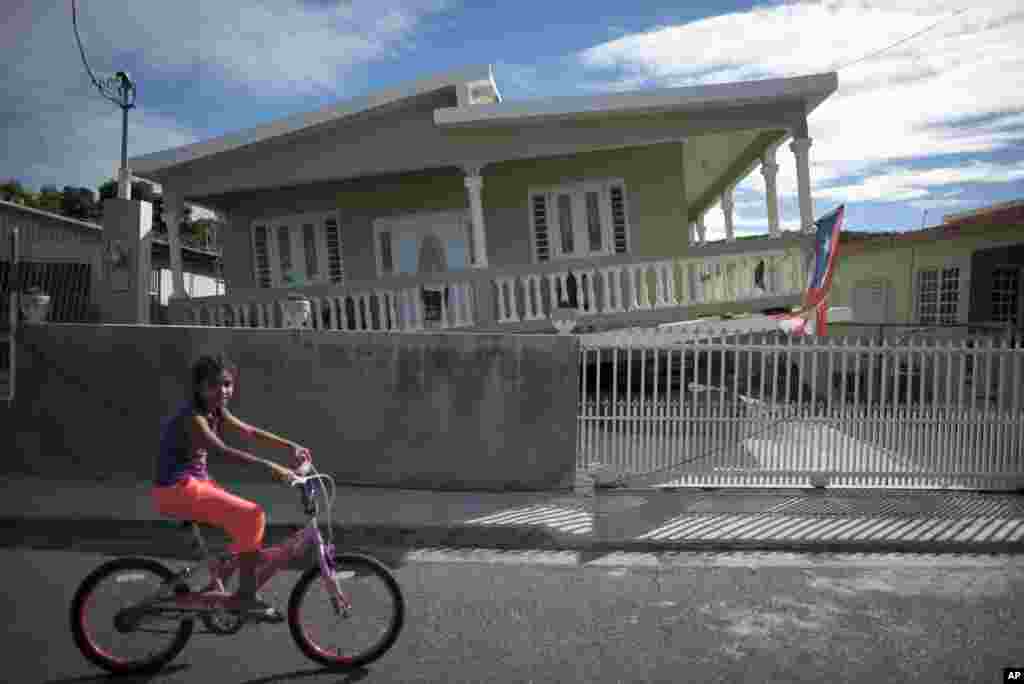 Una niña pasa cerca de una casa que se derrumbó parcialmente después de un terremoto en Guánica, Puerto Rico, el lunes 6 de enero de 2020.