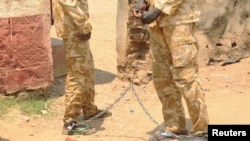 South Sudanese soldiers suspected of beating and raping civilians are chained together at the presidential guard unit, within the Sudan People's Liberation Army headquarters, after their arrest in Juba, March 3, 2017. Witnesses say soldiers killed as many as 16 people in Parjok on April 3. An army spokesman said those killed were "bandits"; a rebel spokesman said it was the soldiers who were doing the looting.