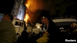 People run away as a fire engulfs The Address Hotel in downtown Dubai in the United Arab Emirates December 31, 2015. (REUTERS/Ahmed Jadallah)