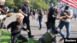 Police officers break up a fight between supporters of U.S. President Donald Trump and Black Lives Matter protesters outside the Oregon State Capitol building in Salem, Oregon, U.S. September 7, 2020.