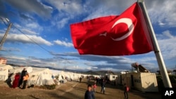 FILE - A Turkish flag flies at the refugee camp for Syrian refugees in Islahiye, Gaziantep province, southeastern Turkey, March 16, 2016. 