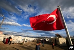 FILE - A Turkish flag flies at a camp for Syrian refugees in Islahiye, Gaziantep province, southeastern Turkey, March 16, 2016. In the past, Turkey’s push for safe zones was seen as tied to its eagerness to oust Syrian President Bashar al-Assad, but now appears more linked to Ankara's desire to stem the flow of refugees.