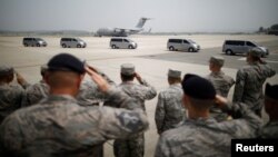 美国军人在韩国乌山空军基地向运送55名在朝鲜战场上牺牲美国军人的遗骸的汽车敬礼