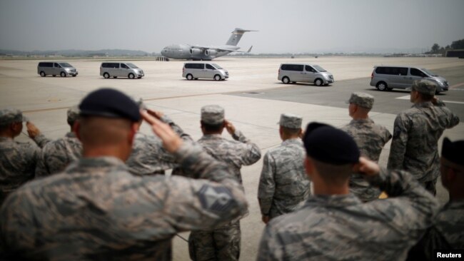 U.S. soldiers salute vehicles transporting the remains of 55 U.S. soldiers who were killed in the Korean War at Osan Air Base in Pyeongtaek, South Korea, July 27, 2018.