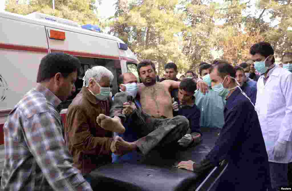 Residents and medics transport a Syrian Army soldier, wounded in what they said was a chemical weapon attack near Aleppo, March 19, 2013.