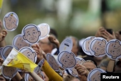 Pilgrims wave cardboard cutouts of Pope Francis before Mass at the Cathedral Basilica of Saints Peter and Paul in Philadelphia, Pennsylvania, Sept. 26, 2015.