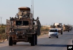 A convoy of U.S. troops drive on a road leading to the tense front line with Turkish-backed fighters, in Manbij, north Syria, March 31, 2018.