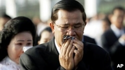 Cambodian Prime Minister Hun Sen and his wife Bun Rany cry during a memorial service near a bridge where festival goers were killed Monday in a stampede in Phnom Penh, Cambodia, Thursday, Nov. 25, 2010. (AP Photo/Sakchai Lalit)