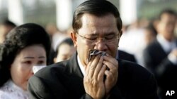 Cambodian Prime Minister Hun Sen and his wife Bun Rany cry during a memorial service near a bridge where festival goers were killed Monday in a stampede in Phnom Penh, Cambodia, Thursday, Nov. 25, 2010. (AP Photo/Sakchai Lalit)