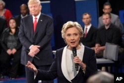 Democratic presidential nominee Hillary Clinton speaks as Republican presidential nominee Donald Trump reacts during the second presidential debate at Washington University in St. Louis, Oct. 9, 2016.