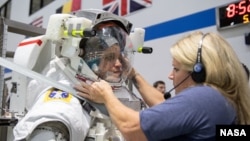 In this May 22, 2019, photo, 2017 NASA astronaut candidate Jessica Watkins is helped into a spacesuit prior to underwater spacewalk training at NASA Johnson Space Center’s Neutral Buoyancy Laboratory in Houston. Photo Credit: (NASA/David DeHoyos)