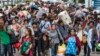 Cambodian migrant workers carry their belongings as they walk to cross the border at Aranyaprathet in Sa Kaew, June 15, 2014. 