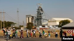 Members of the mining community carry food parcels donated by an Aid organisation, Gift of the Givers, at the Khomanani mine in Rustenburg, South Africa, May 28, 2014. 