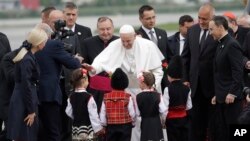 El papa Francisco es recibido por niños vestidos con trajes tradicionales a su llegada a Sofía, Bulgaria, el domingo 5 de mayo de 2019. (AP Foto/Alessandra Tarantino)