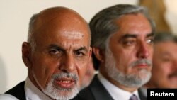 FILE - Afghanistan's presidential candidate Ashraf Ghani (L) speaks with rival candidate Abdullah Abdullah (R) at his side during a news conference in Kabul, July 12, 2014. 