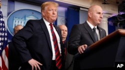 President Donald Trump, left, listens as Brandon Judd, president of the National Border Patrol Council, talks about border security after making a surprise visit to the press briefing room of the White House in Washington, Jan. 3, 2019. 
