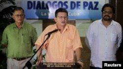 Revolutionary Armed Forces of Colombia (FARC) negotiator Pablo Catatumbo (C) reads a document as FARC lead negotiator Ivan Marquez (R) and FARC negotiator Ricardo Tellez listen in Havana, Aug. 23, 2013. 